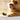 Dog with tongue out lying on a surface, wearing black PawSteady Grip Pads.